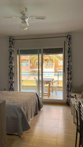 a bedroom with a bed and a patio with a table at Roquetas "Estudio acogedor cerca del Castillo y del puerto de Roquetas, aireconditionado" in Roquetas de Mar