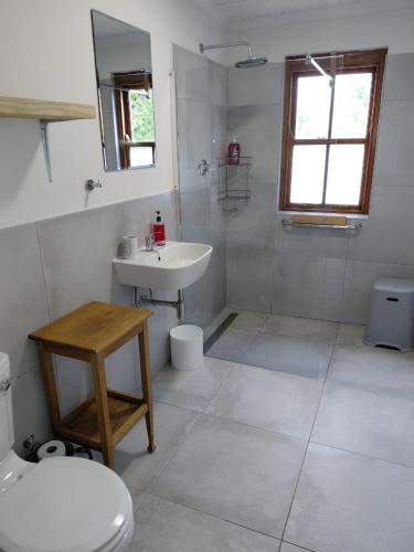 a white bathroom with a sink and a toilet at The Galleons in Barrydale