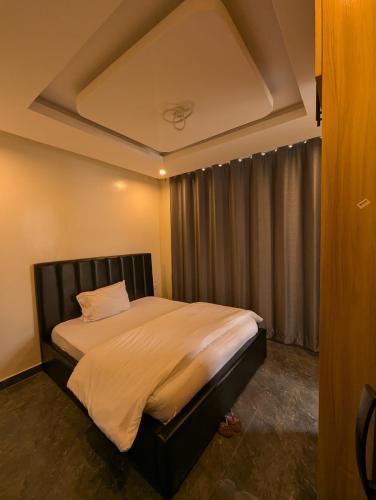 a bedroom with a large bed in a room at KIGALI E6 APARTMENTs RESORTS in Kigali