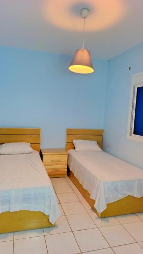 a bedroom with two beds and a light fixture at Comfort Apartment in Einzorene
