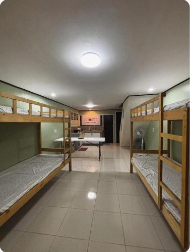 ein Zimmer mit drei Etagenbetten und einem Tisch in der Unterkunft The Zion Bedspace- Olongapo City in Olongapo