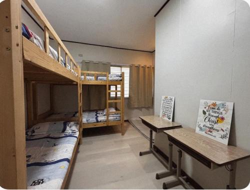 ein Zimmer mit zwei Etagenbetten und einem Schreibtisch in der Unterkunft The Zion Bedspace- Olongapo City in Olongapo