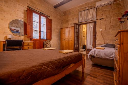 a bedroom with a bed and a desk and a window at 3Cities Maison close to Valletta in Cospicua