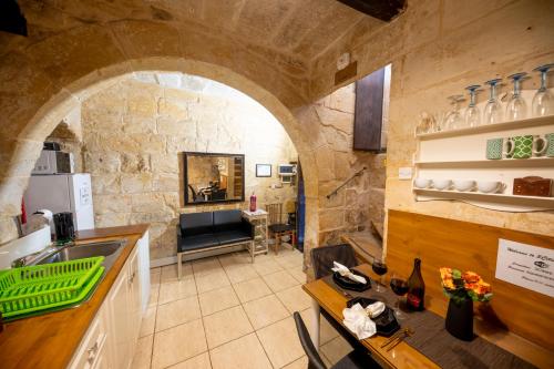 a kitchen with an archway in a stone building at 3Cities Maison close to Valletta in Cospicua
