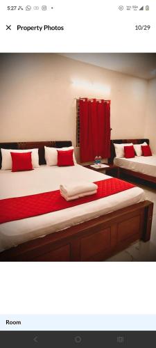a bedroom with two beds with red and white pillows at MKR GRANd in Rāmeswaram