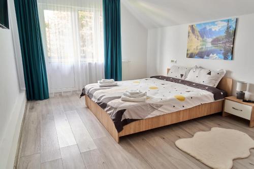 a bedroom with a large bed with green curtains at Casa Sofisa in Fundata