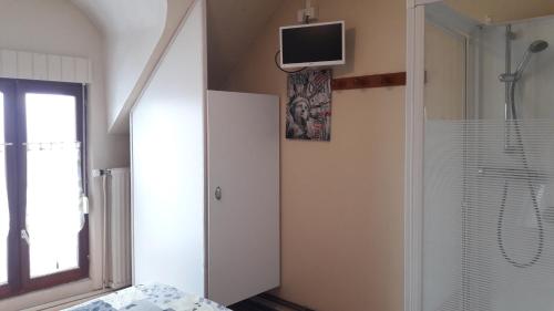 a bedroom with a shower and a tv on the wall at Le Relais De Risquetout in Hem-Hardinval