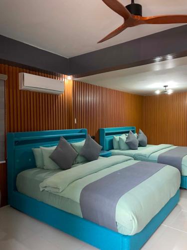 two beds in a room with two blue at Cave Beach Resort - Boutique Accomodation in Dingalan