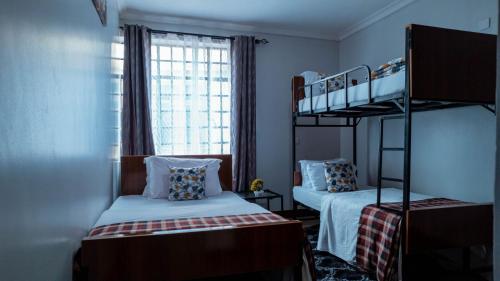 a bedroom with two bunk beds and a window at MINA CHAI HOUSE BNB in Arusha