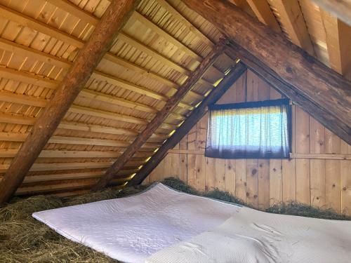 a bedroom in a barn with a window at Heinaküün - magamine heinalakas in Pärna