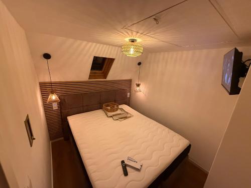 a small room with a bed with a bottle and a bag on it at EJ Apartments in Gartow