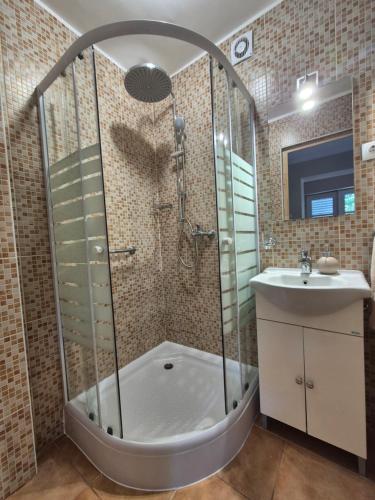 a bathroom with a shower and a sink at Tóthék Apartman in Szigetvár