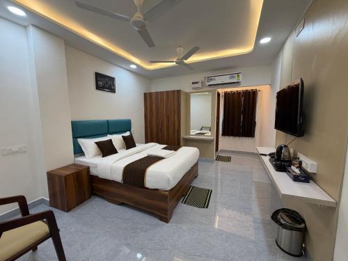 a bedroom with a large bed and a television at Hotel V Stay in Chennai