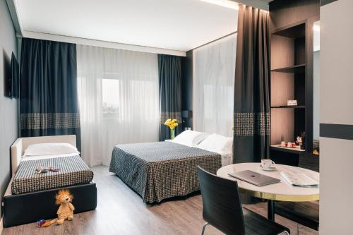 a hotel room with a bed and a table at The Sydney Hotel in Bologna