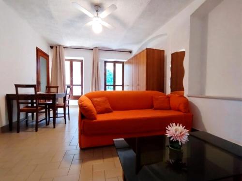 a living room with an orange couch and a table at Will House 1 in Lanzo Torinese