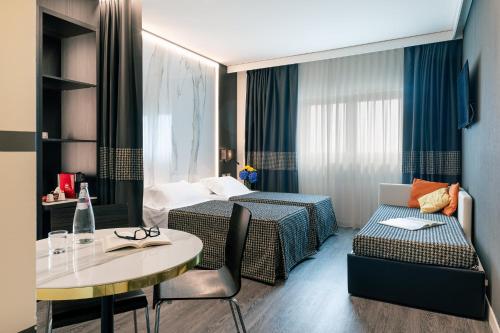 a hotel room with a bed and a table at The Sydney Hotel in Bologna