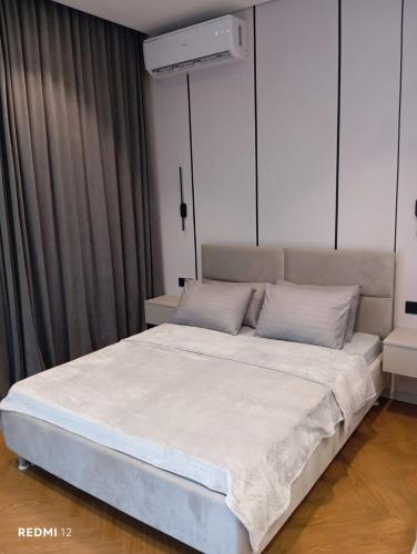 a bedroom with a large bed with white sheets at Sea Breeze Vibe in Nardaran
