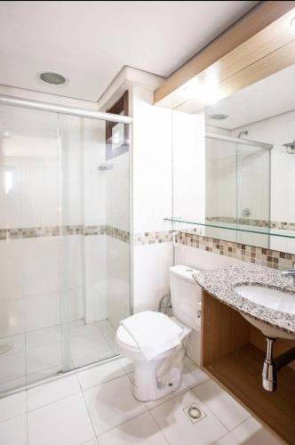 a bathroom with a shower and a toilet and a sink at Beach Front Apartment Kariri in Caucaia