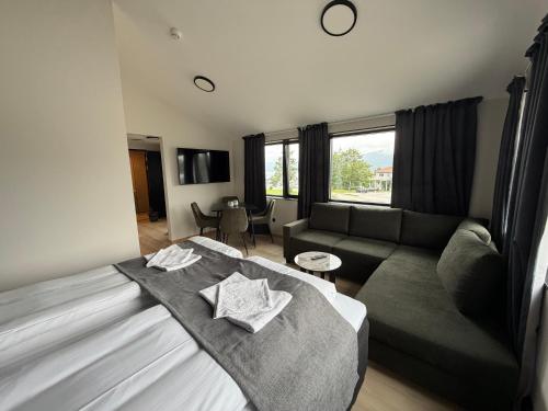 a living room with a bed and a couch at Hotell Sjyen in Nesna