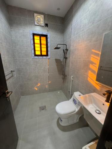 a bathroom with a toilet and a sink and a window at شاليه in Al Baha