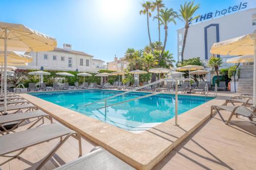 a swimming pool with chairs and umbrellas at a hotel at THB Gran Playa - Adults Only in Can Picafort