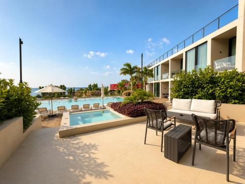 a patio with chairs and a swimming pool at Inanna Resort in Kifrayyā