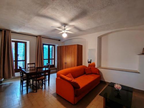 a living room with an orange couch and a table at Will House 1 in Lanzo Torinese
