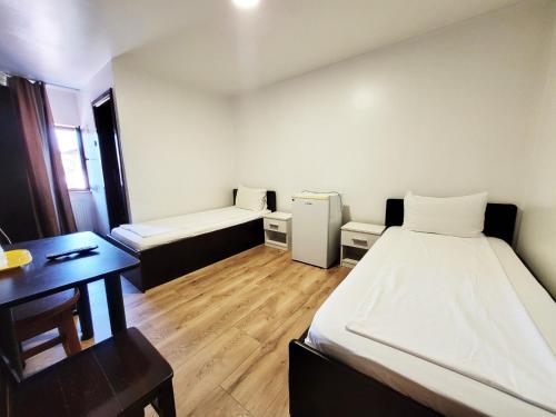 a small room with a bed and a desk with a desk at Pensiune Iguana in Tulcea