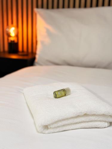 a bottle on a white towel on a bed at APARTMÁNY za divadlem in Broumov