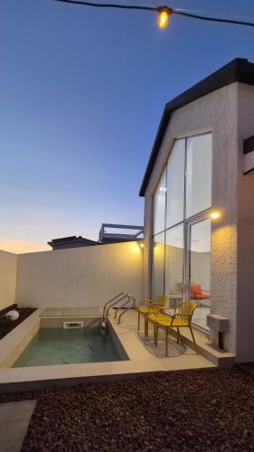a house with a swimming pool with a table and chairs at 애월현스테이 in Kumori-dong