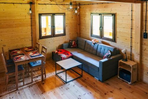 a living room with a couch and a table at Lisie Bagno - Domki w Lesie Mazury in Miłomłyn