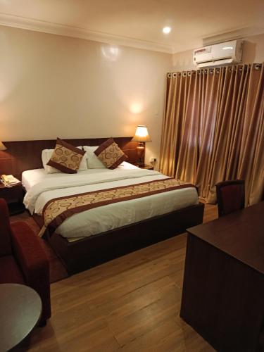a hotel room with a bed and a window at Grand Inn & Suites in Ijebu Ode