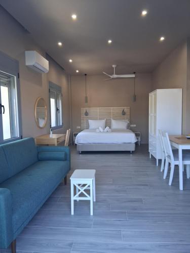 a bedroom with a bed and a couch and a table at katina 26 in Pitsidia