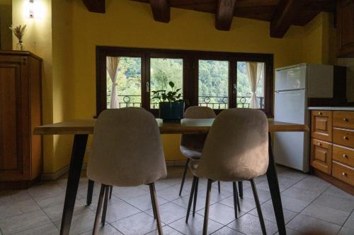 a kitchen with a wooden table and four chairs at Casa Ferrero - appartamenti in Paesana
