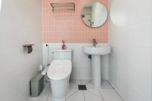 a bathroom with a toilet and a sink and a mirror at 애월현스테이 in Kumori-dong