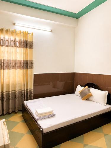 a bedroom with a bed and a shower at Kiến An Hotel Cần Thơ in Can Tho