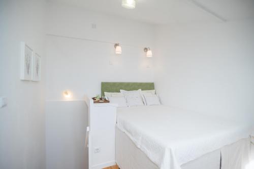 een kamer met witte muren en een bed met een tafel bij Little River View Triplex in Alfama in Lissabon