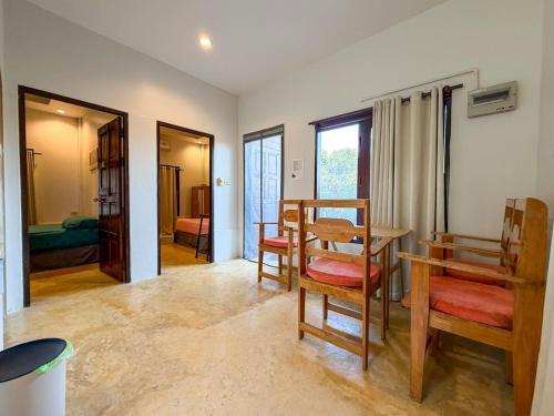 a living room with a table and chairs and a bedroom at Neziha's Homes in Thong Sala