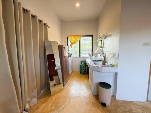 a small bathroom with a sink and a mirror at Neziha's Homes in Thong Sala