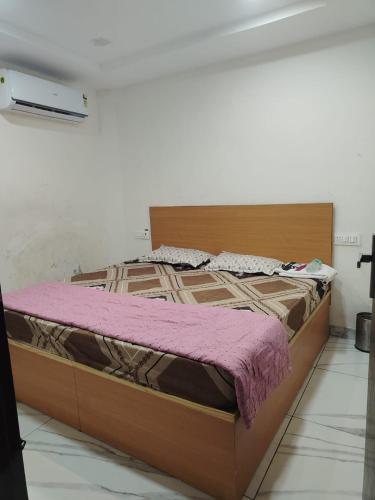 a large bed with a wooden frame in a room at Hotel Tokyo in Bathinda