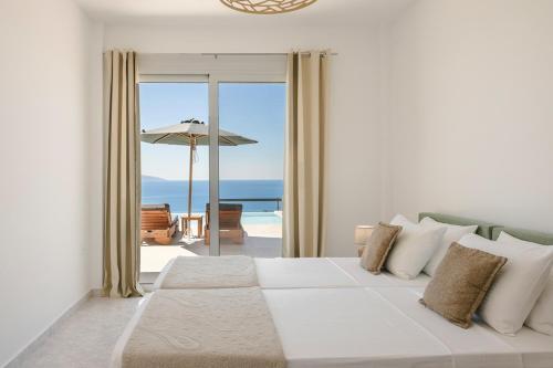 a bedroom with a bed with a view of the ocean at Ionian Dreaming in Lourdata
