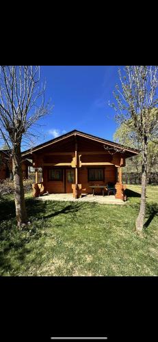 a log cabin with two trees in front of it at Chalet 2 chambres à Estavar in Estavar