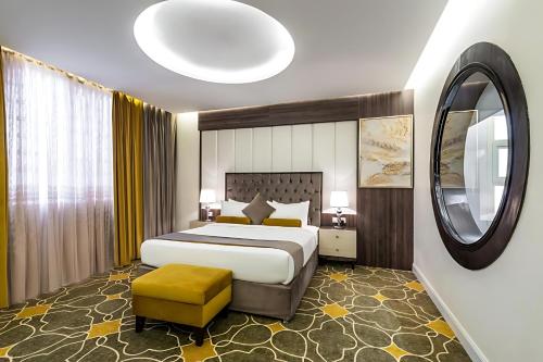 a bedroom with a large bed and a large mirror at فندق اورا ميلينيوم in Al Maraghah