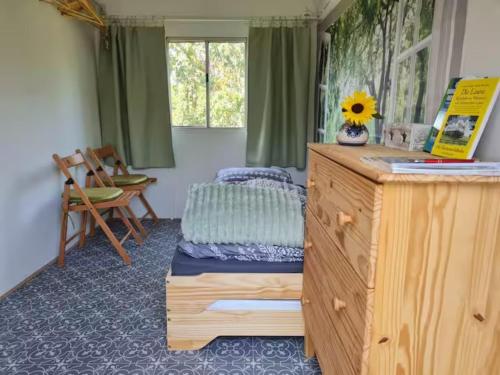 a bedroom with a bed and a desk with a sunflower on it at Gemütlicher Rustikaler Bauwagen in Vippachedelhausen
