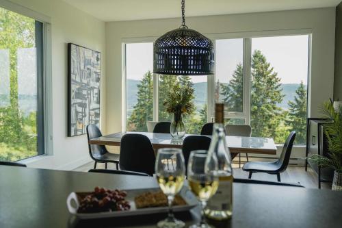 a dining room with a table with glasses of wine at 211 - Bright Condo - Pool and Cozy Atmosphere in Baie-Saint-Paul