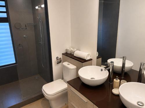 a bathroom with a toilet and a sink and a shower at Azuri Appartement De Luxe & Pool in Roches Noires