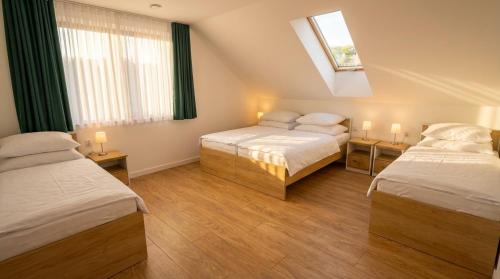 a hotel room with two beds and a window at Noce pod Gwiazdami in Sidzina