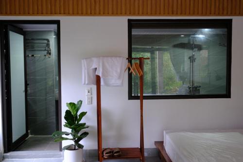 a bedroom with a shower and a mirror and a plant at Chải Eco House in Mù Cang Chải