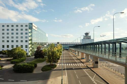 an empty city street with a bridge and buildings at Courtyard by Marriott Prague Airport in Prague