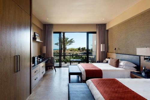 a hotel room with two beds and a balcony at JW Marriott Los Cabos Beach Resort & Spa in San José del Cabo